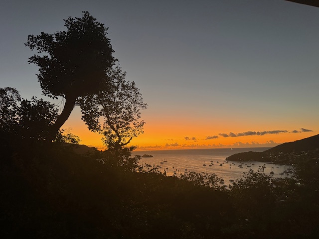 Sunset view over a harbor with anchored boats