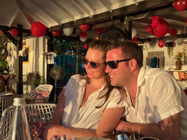 Couple smiling at a sunset dinner