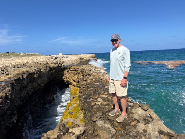 Man standing on rocky coast above the water