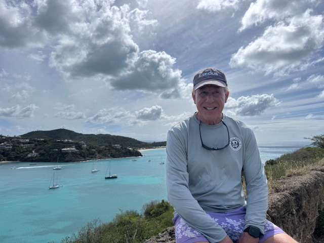 Man seated above a turquoise bay view